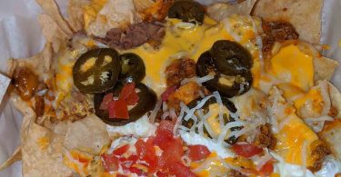 Epic Beef Nachos Supreme: A piled high plate of tortilla chips loaded with savory beef, cheese, and all your favorite nacho toppings, perfect for game day or a party.