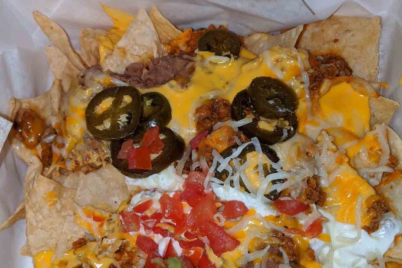 Epic Beef Nachos Supreme: A piled high plate of tortilla chips loaded with savory beef, cheese, and all your favorite nacho toppings, perfect for game day or a party.