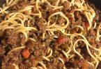 Delicious Old Fashioned Spaghetti cooked in a crock pot with ground beef, onions, and tomatoes for a rich and flavorful meal.
