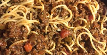 Delicious Old Fashioned Spaghetti cooked in a crock pot with ground beef, onions, and tomatoes for a rich and flavorful meal.